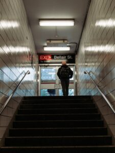 A man stands at the Bellair St. exit of a Toronto subway station, ready to step into the city streets.