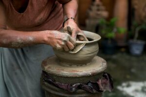 A skilled potter shaping clay on a wheel, showcasing traditional craftsmanship and creativity.