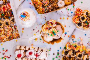 Vibrant selection of ice cream and candy treats on a marble background.