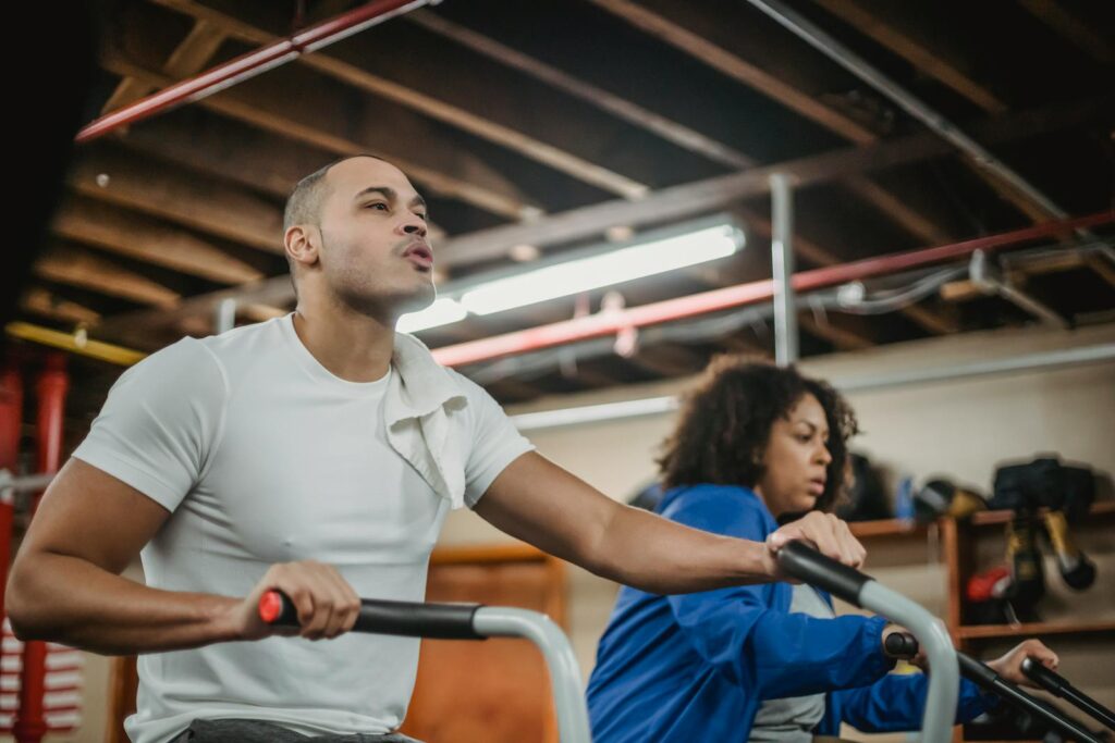 Focused gym session with diverse trainers cycling energetically indoors.