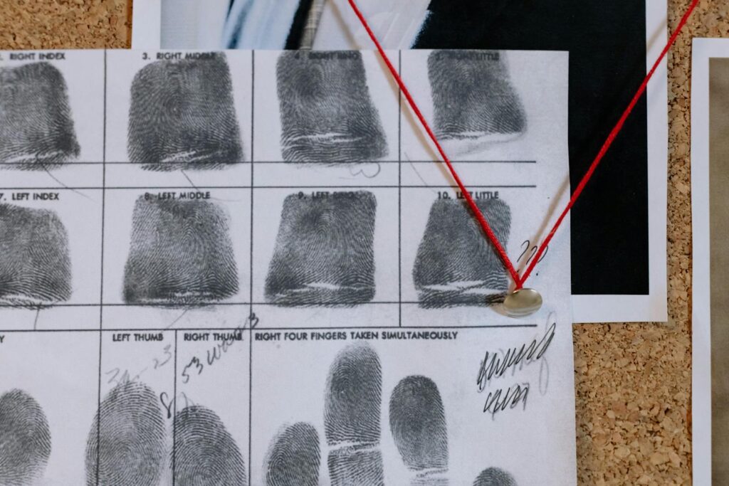 Detailed close-up of fingerprint card pinned on a corkboard, showcasing identity documentation.