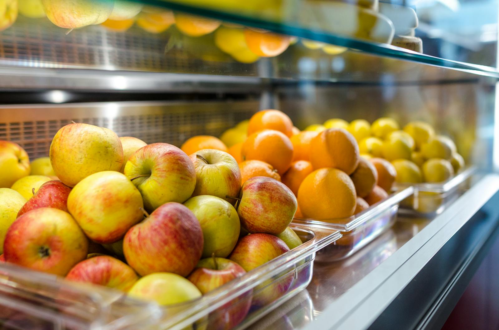 Close-up of fresh apples and oranges on display at a market stall. Vibrant and healthy.