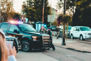 Police officers and vehicles on a busy city street, Wheeling, WV in daylight.