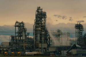 A detailed view of a refinery's towers against a cloudy dusk sky, showcasing industrial architecture.