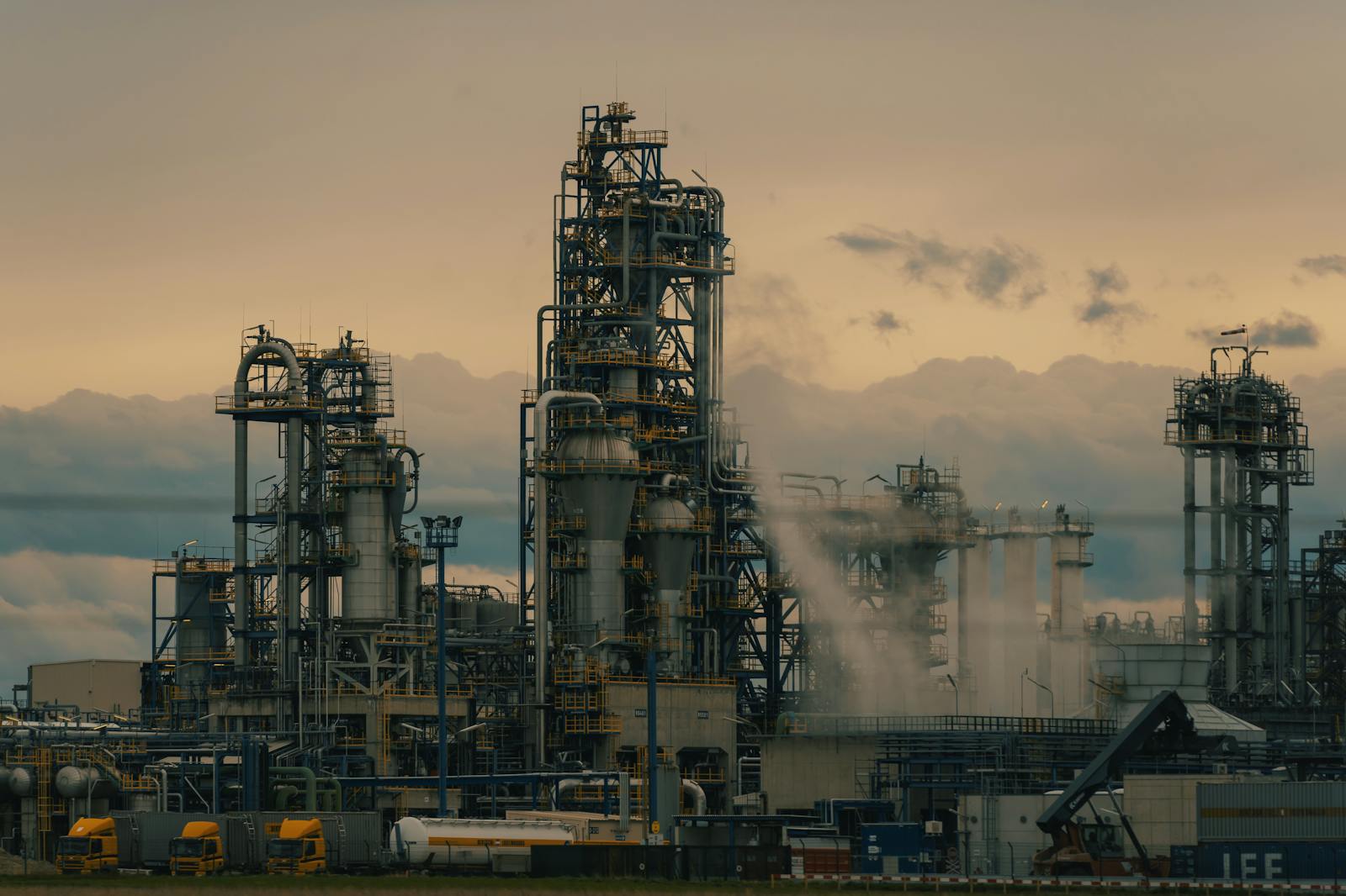 A detailed view of a refinery's towers against a cloudy dusk sky, showcasing industrial architecture.
