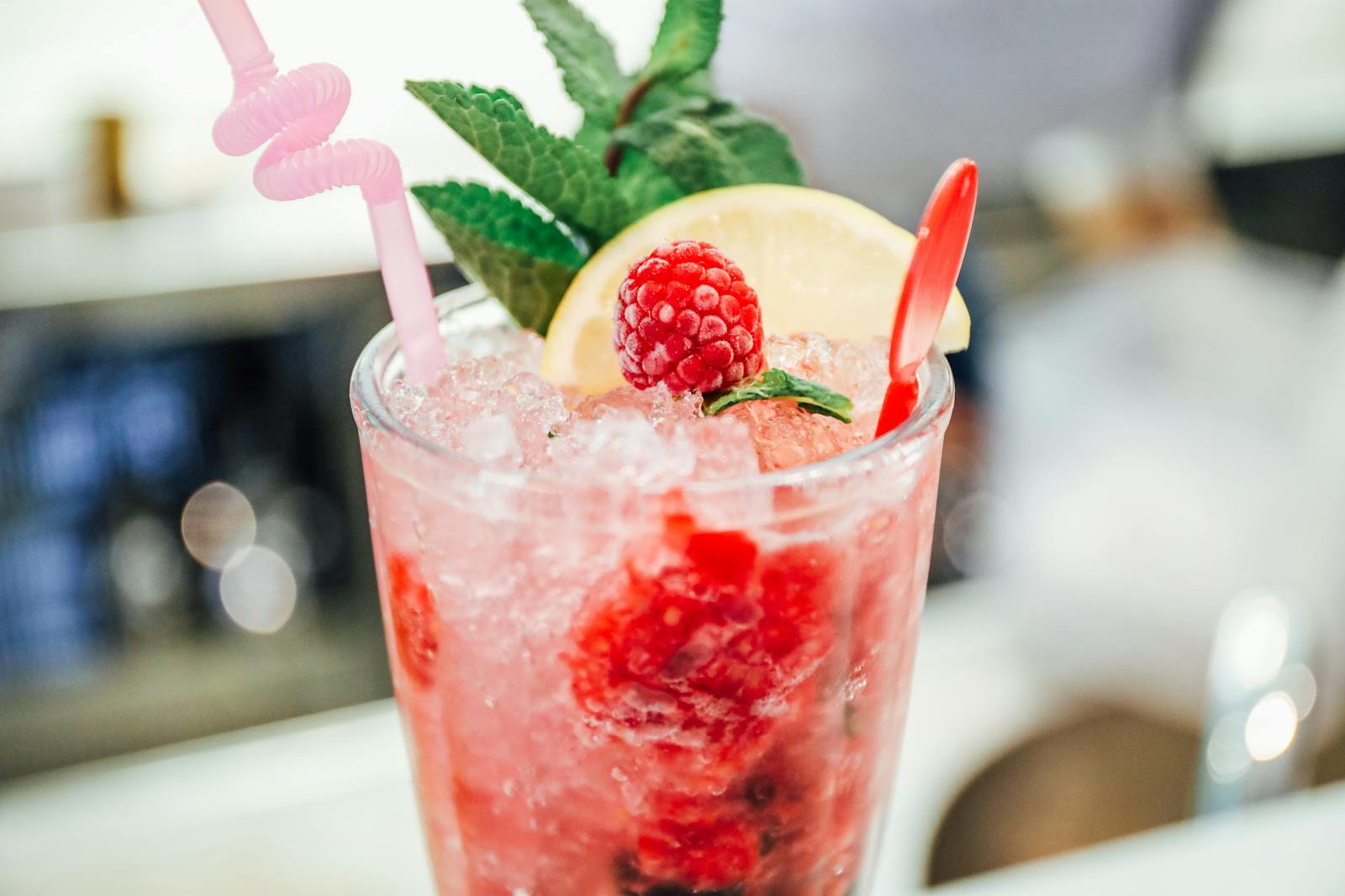 Cool raspberry lemonade cocktail with mint, lemon slice, and ice. Perfect for a refreshing drink on a summer day.