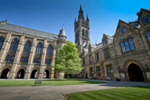 View of the stunning historic University of Glasgow courtyard under a clear blue sky.