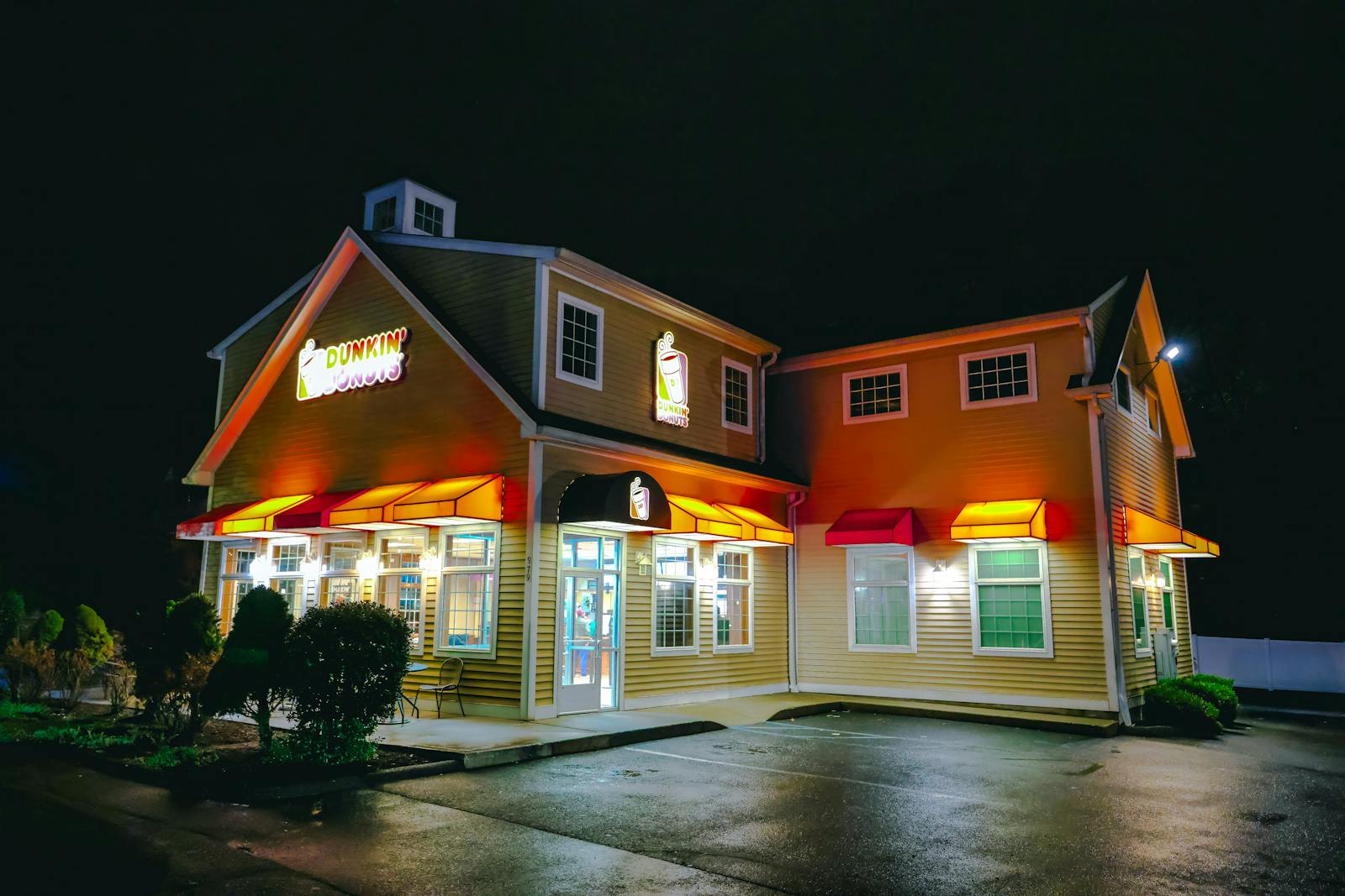 A Dunkin' Donuts storefront illuminated at night in Stamford, Connecticut.