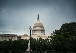 A dramatic capture of the US Capitol Building in Washington, DC with surrounding greenery.