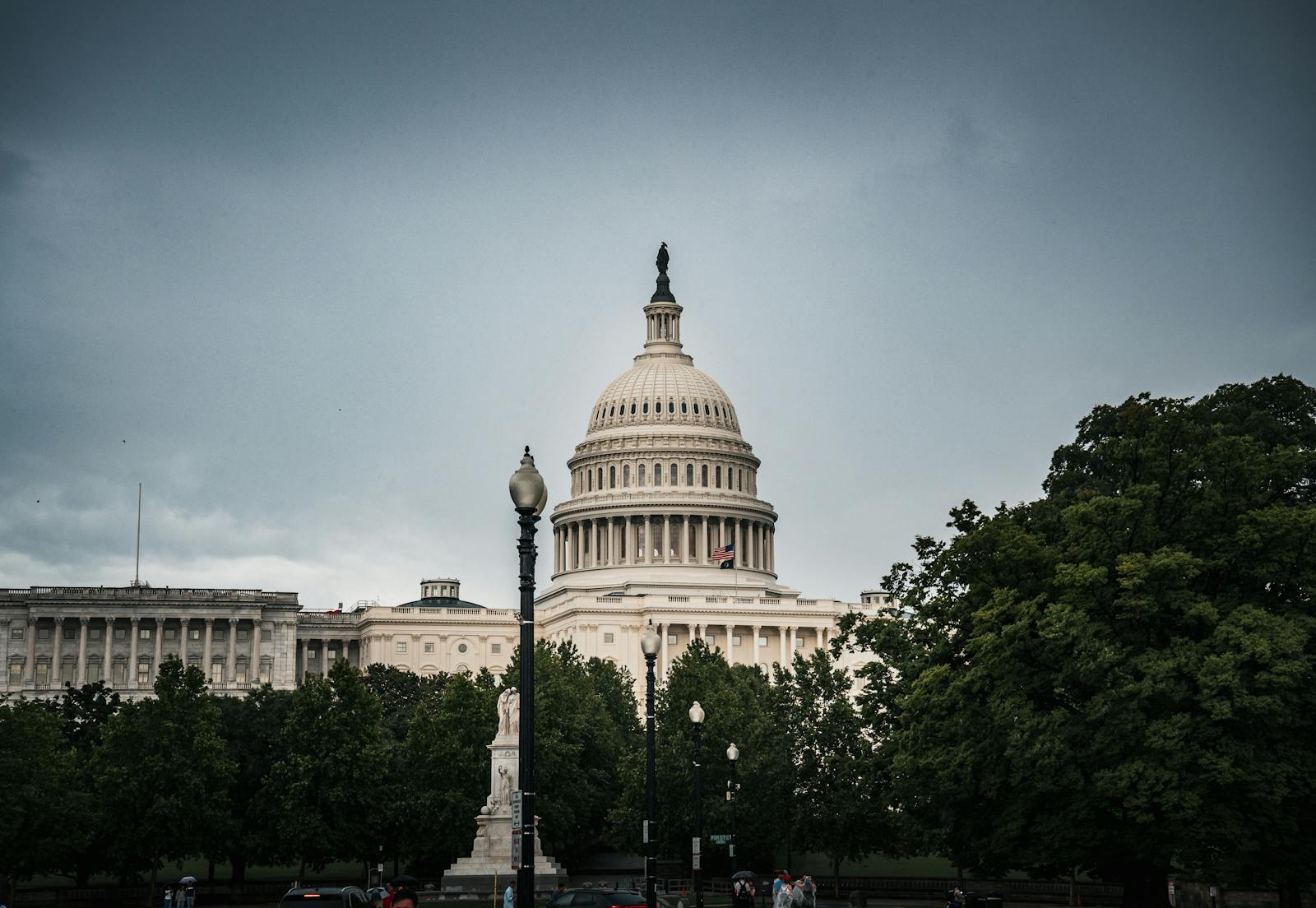 A dramatic capture of the US Capitol Building in Washington, DC with surrounding greenery.