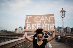 A protester holds an 'I Can't Breathe' sign during a demonstration on a bridge.