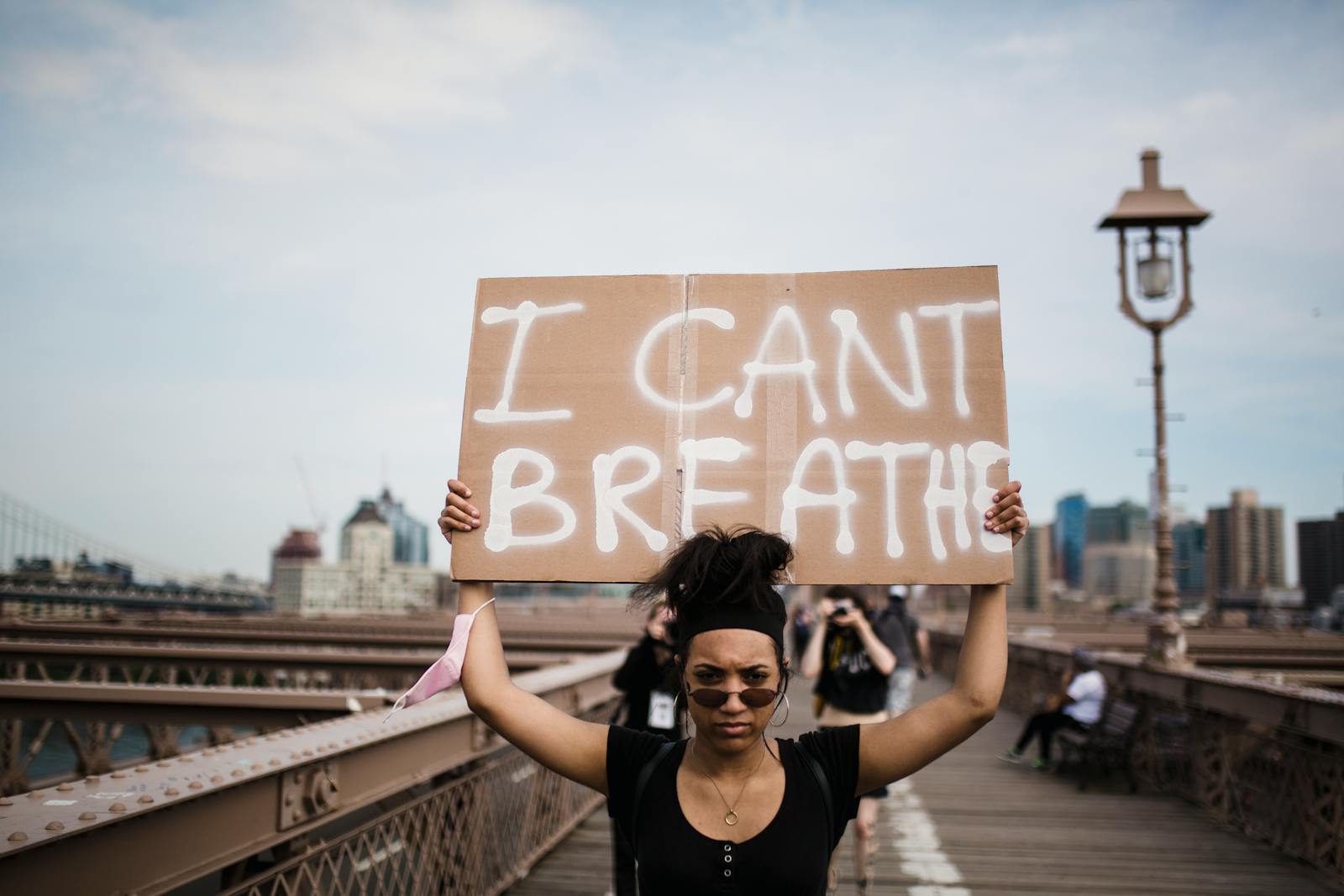 A protester holds an 'I Can't Breathe' sign during a demonstration on a bridge.