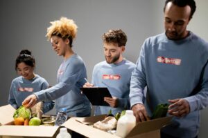 Four diverse volunteers pack food donations with teamwork and dedication.