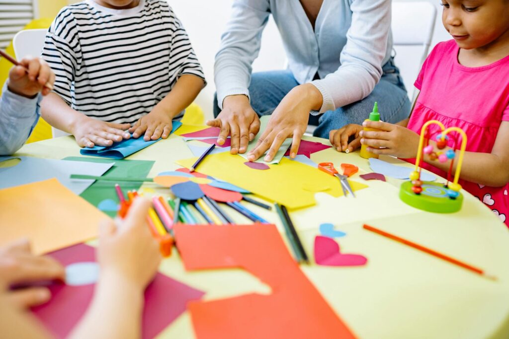 Group of diverse children enjoying creative art activities in a vibrant classroom setting.