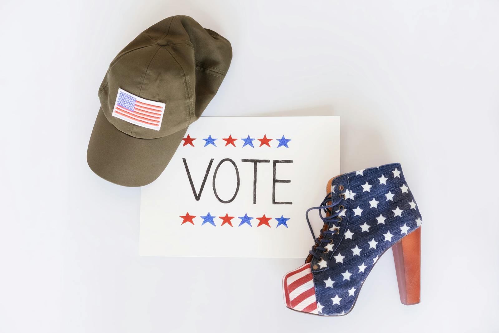 A patriotic setup featuring a cap, a vote sign, and a high-heeled shoe with US flag design.