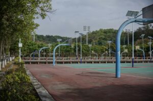 Empty basketball court with curved hoops and lights.