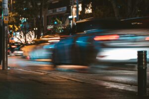 Long exposure capture of urban traffic showcasing light streaks and busy city life at night.