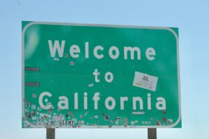 a welcome to california sign with stickers on it