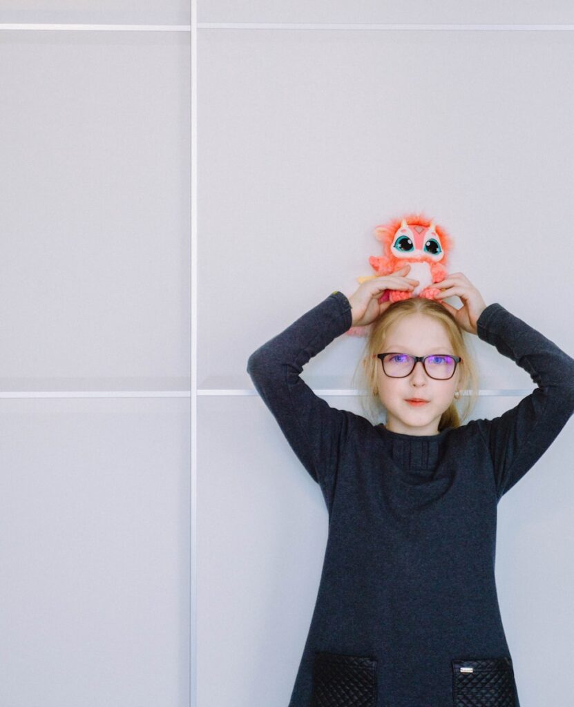 a little girl holding a pair of eyeballs over her head